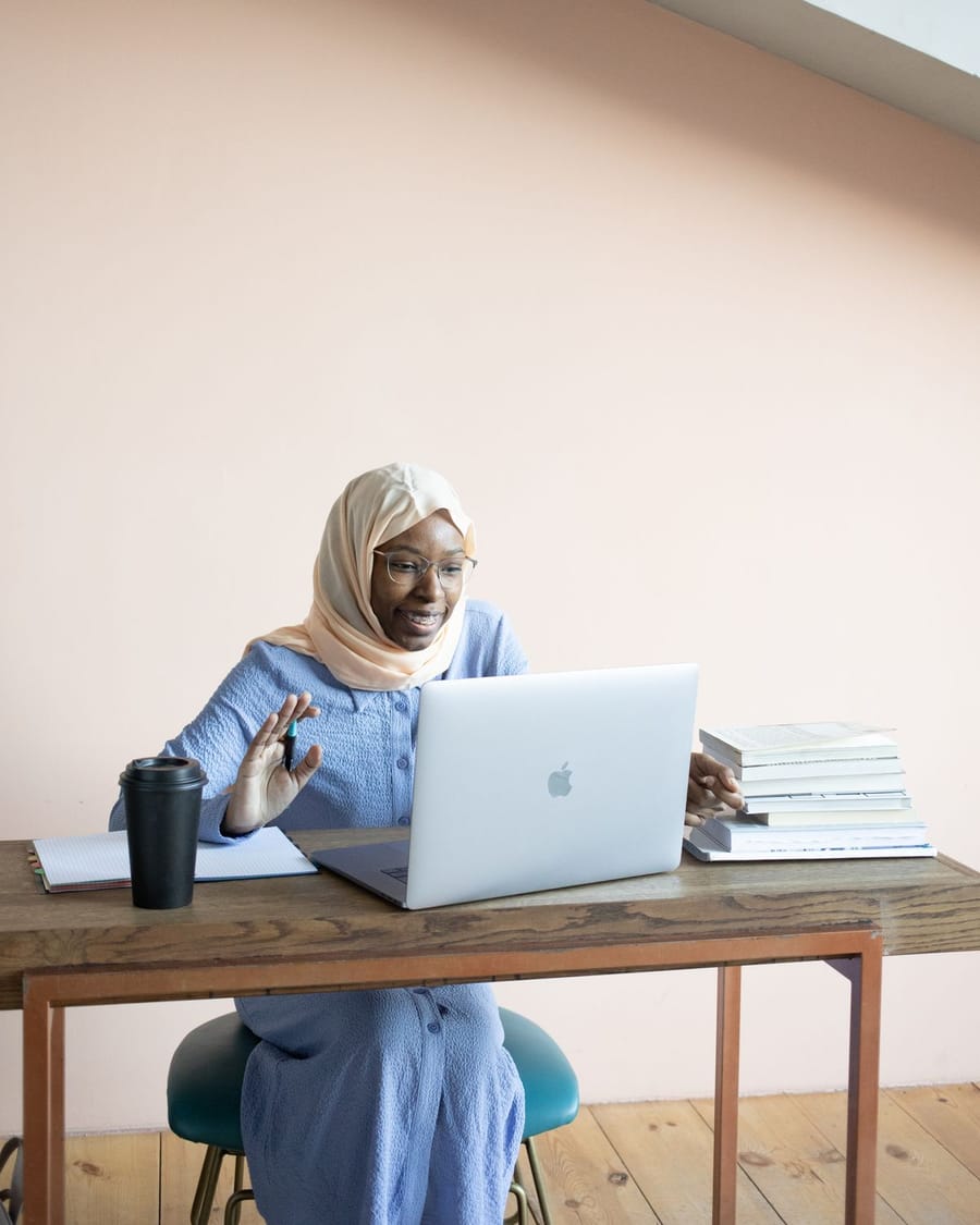 Smiling student waves during an online lesson.